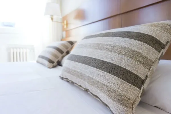 A hotel bed with striped pillows