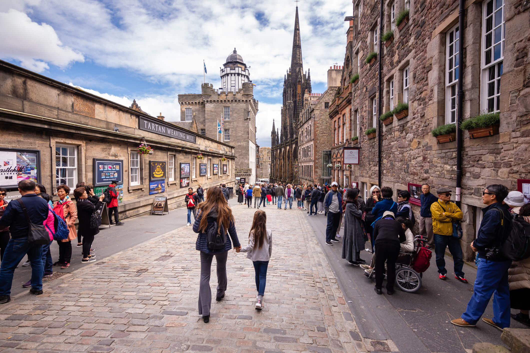 tourists walking along historic edinburgh street