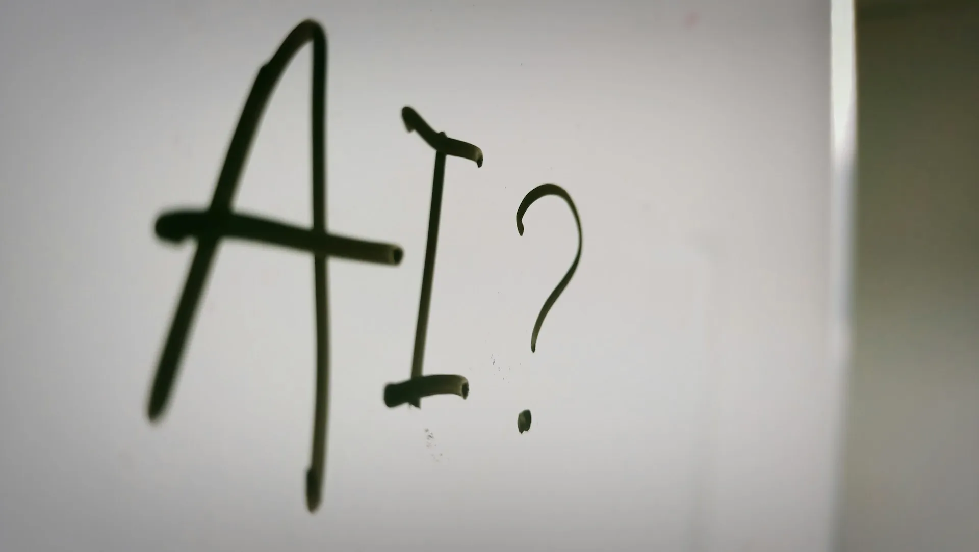 AI stock image - photo of AI written on whiteboard with question mark after it