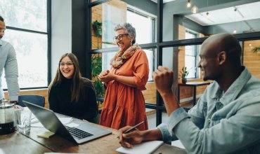 Diverse businesspeople smiling cheerfully during a meeting in a modern office. Group of successful businesspeople working as a team in a multicultural workplace.