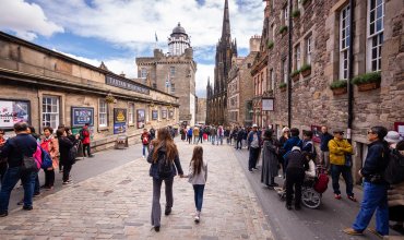 tourists walking along historic edinburgh street